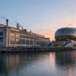 Vue panoramique de l'île Seguin avec les anciennes usines Renault et la Seine Musicale au crépuscule.