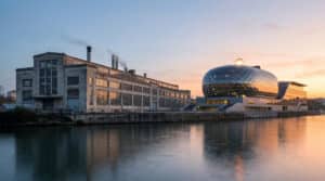Vue panoramique de l'île Seguin avec les anciennes usines Renault et la Seine Musicale au crépuscule.