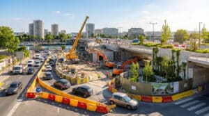 Travaux en cours au Pont de Sèvres avec grues, engins de chantier, voitures déviées et espaces verts en construction.